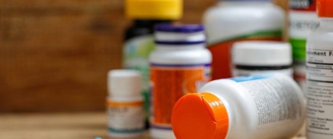 Medicine bottles and tablets on wooden desk